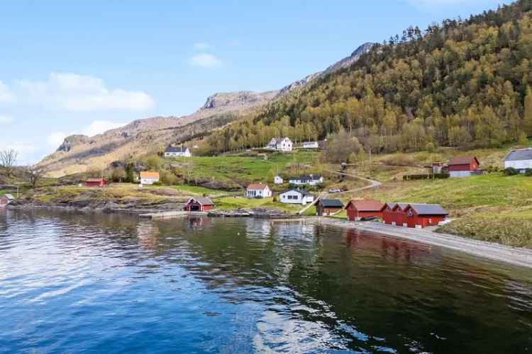 Hytte ved sjøen med strandlinje og brygge